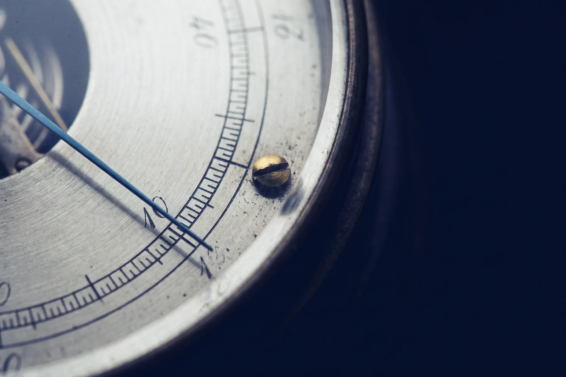 Close-up of an analogue measuring dial, its needle resting against a fine engraved scale.
